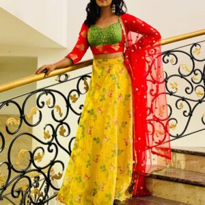 Elegant woman in custom-stitched floral lehenga with green blouse and red dupatta